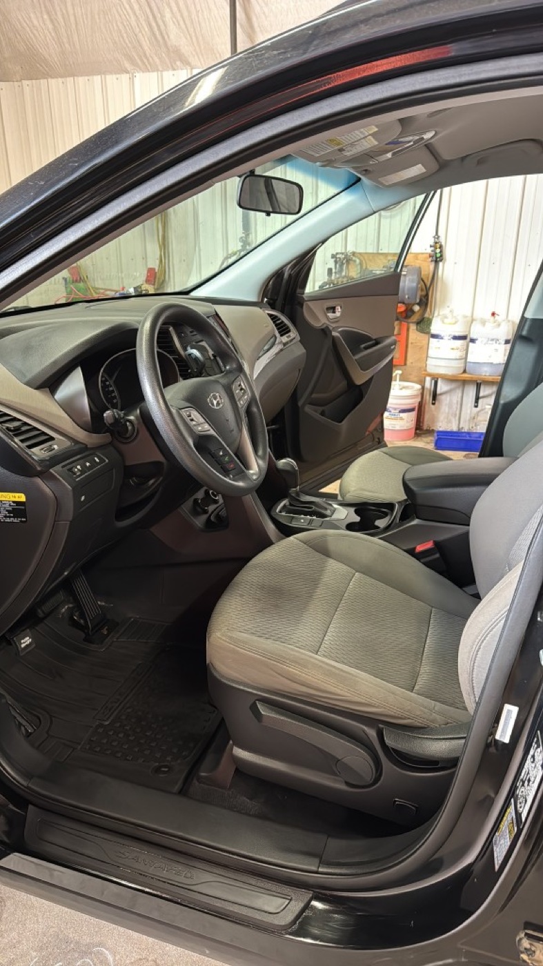 Same vehicle interior after Daily Detail — clean seats, mats, and dashboard