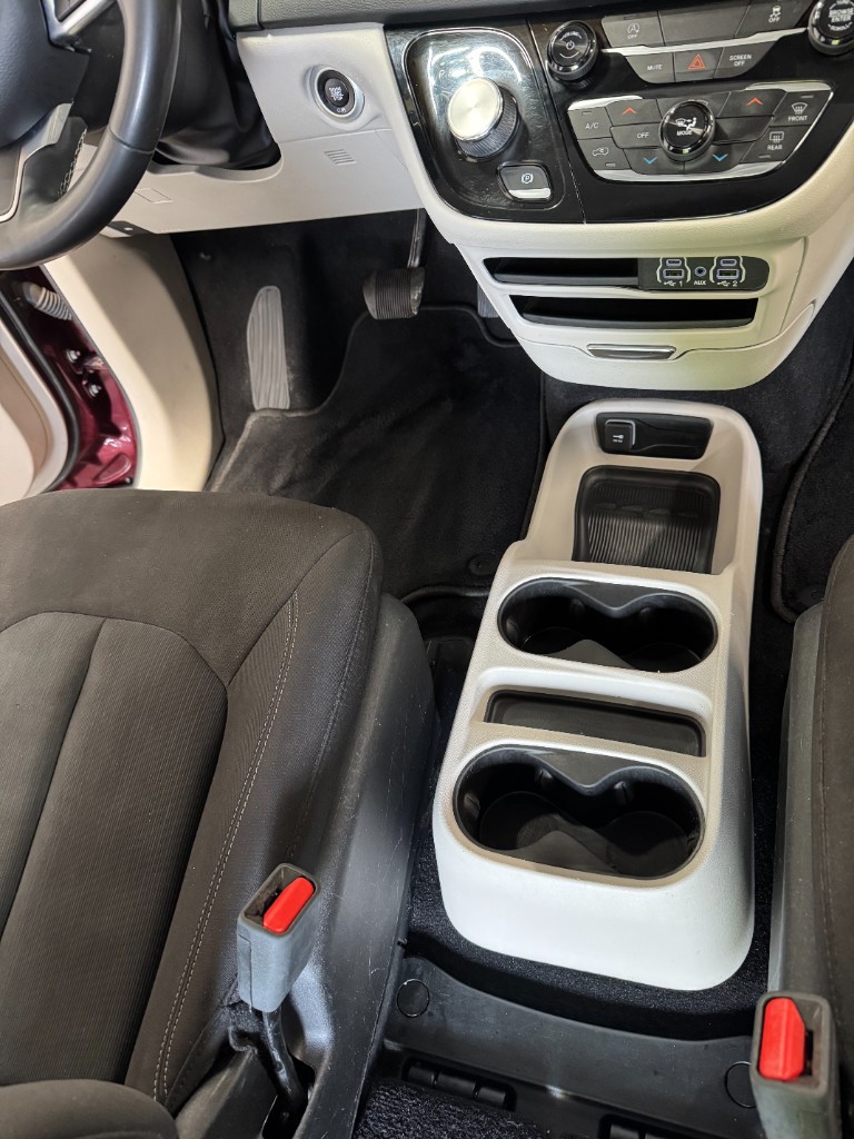 Same center console after Daily Detail — clean cup holders, storage bins, and floor mats